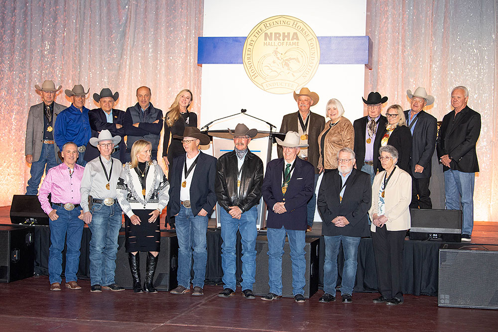 Group of people in cowboy hats and medals, standing on stage at an awards event.