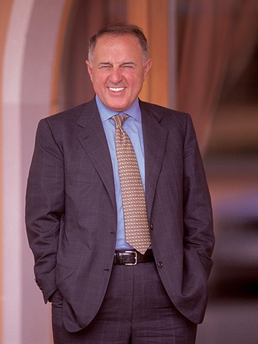 Smiling man in formal attire at an indoor event