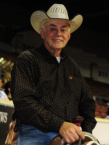 Smiling man wearing a cowboy hat at an indoor event